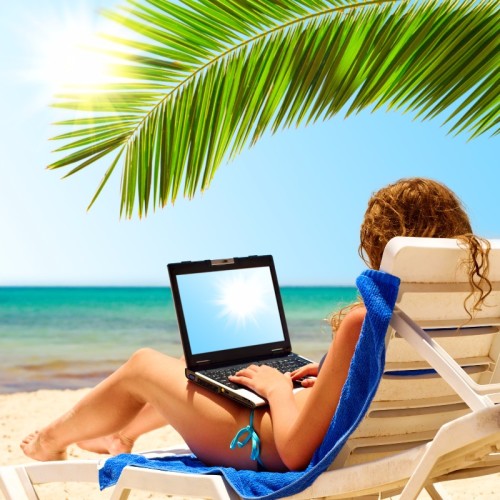 surfing on the beach. Laptop display is cut with clipping path